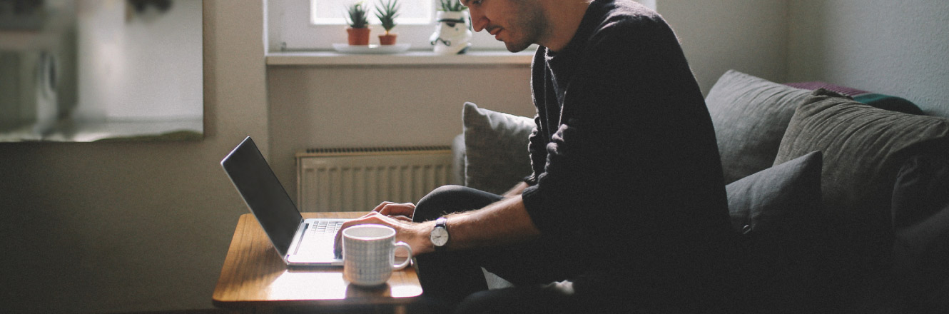 individual working on a laptop on their couch