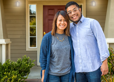 a couple in front of a house